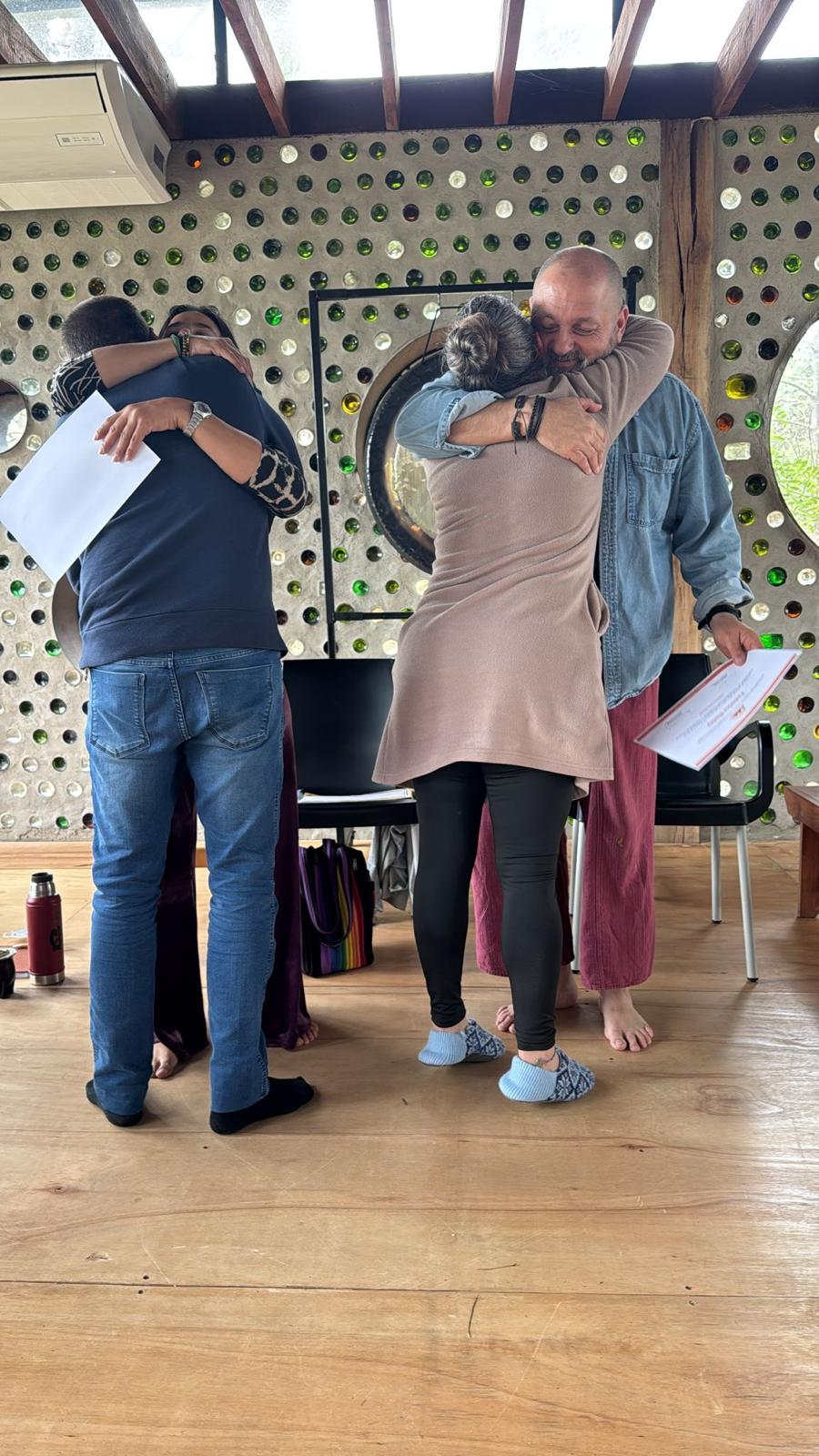 Abrazos entre participantes y docentes durante la entrega de certificados